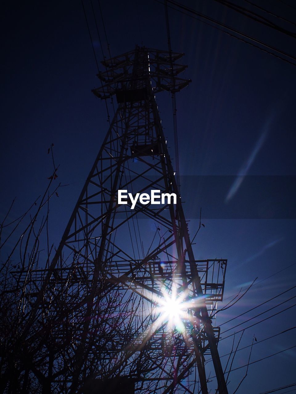 LOW ANGLE VIEW OF ELECTRICITY PYLON AT SUNSET