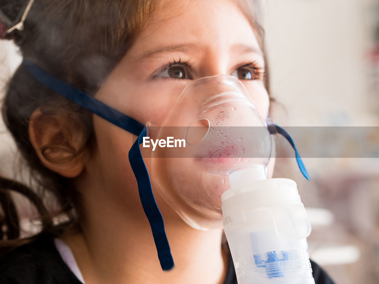 Close-up of girl wearing oxygen mask in clinic