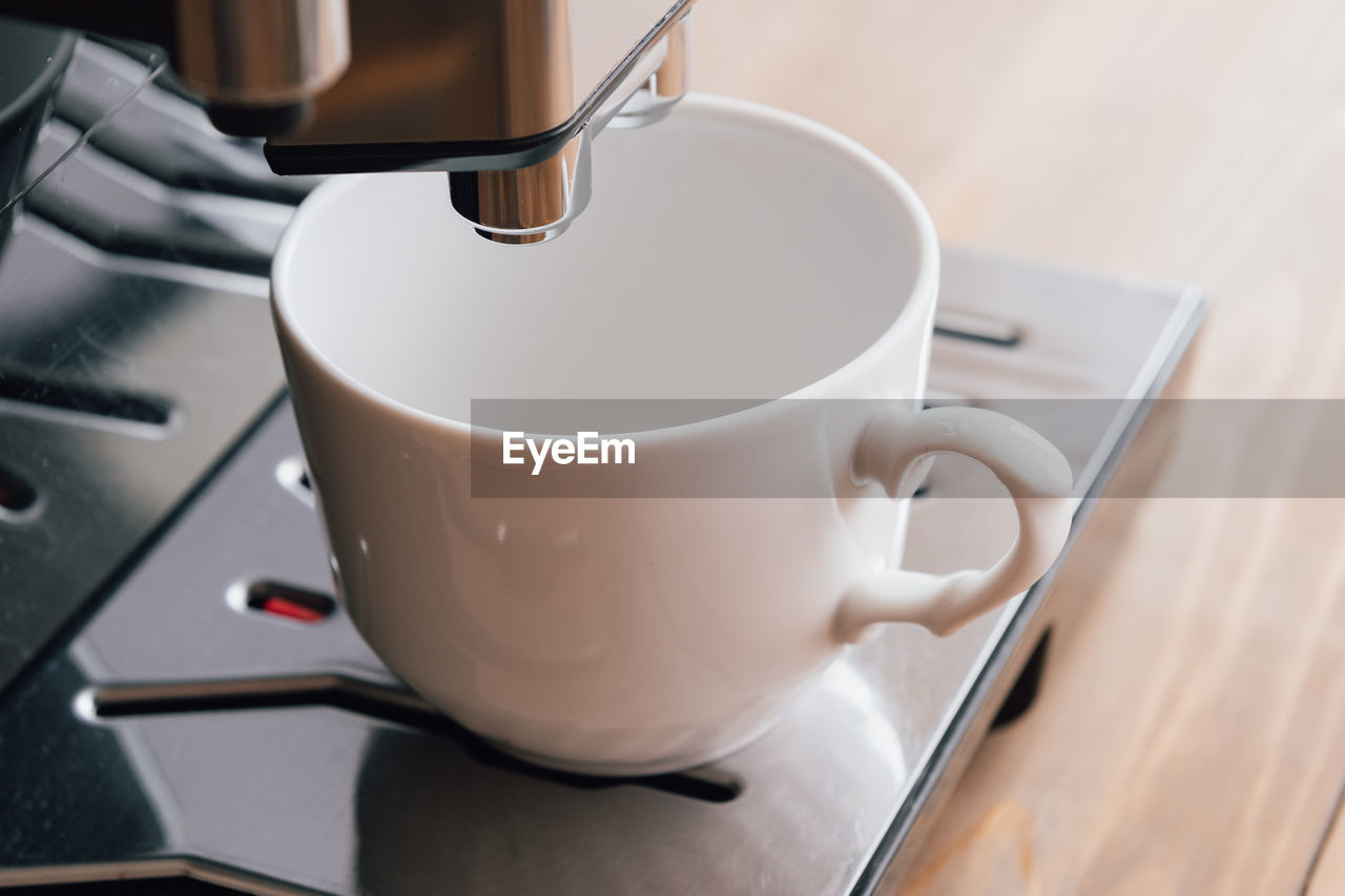 Wooden desk and stylish coffee machine on it