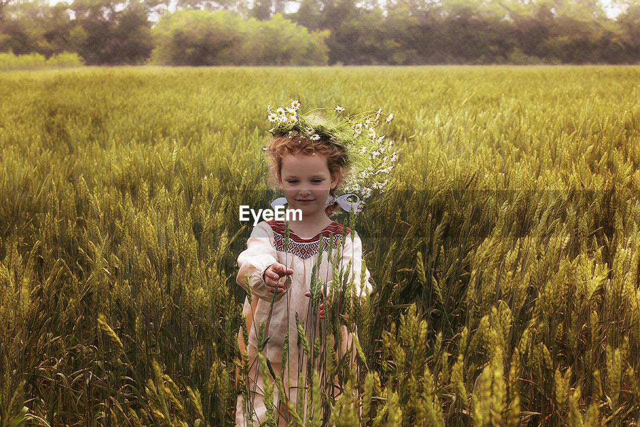 PORTRAIT OF GIRL STANDING IN FIELD