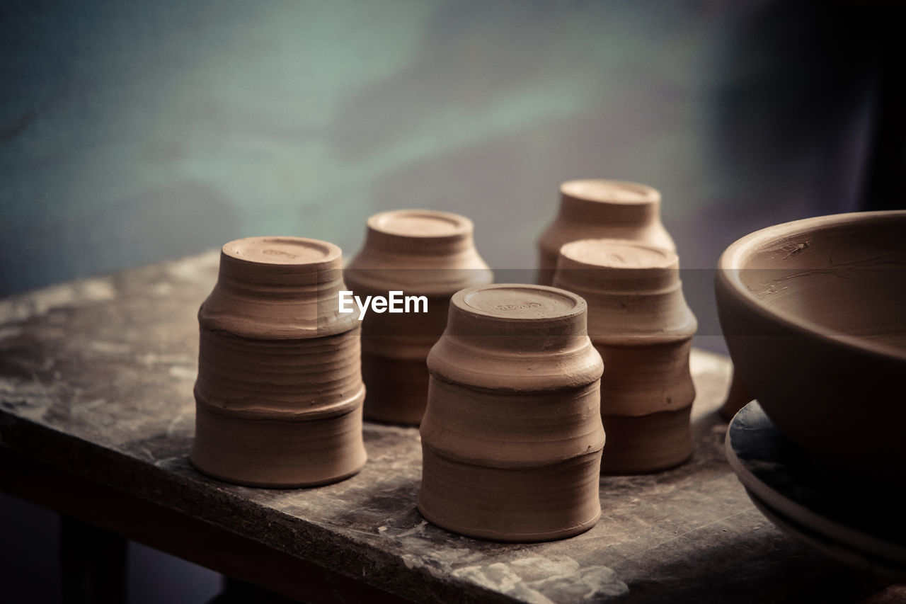 Ceramic clay products stand on the shelf close-up. sculptor sculpts pots products from white clay. 