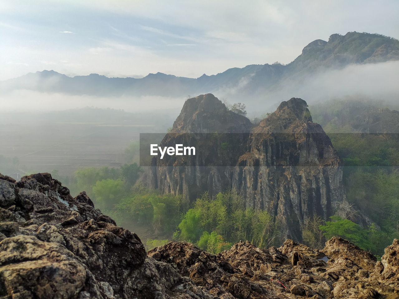 Scenic view of mountains against sky and fog.