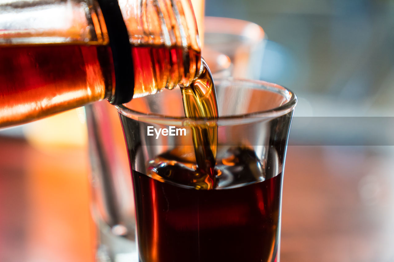 CLOSE-UP OF WINEGLASS ON GLASS OF WINE