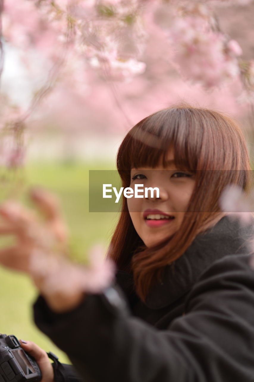 Smiling woman with bangs in public park