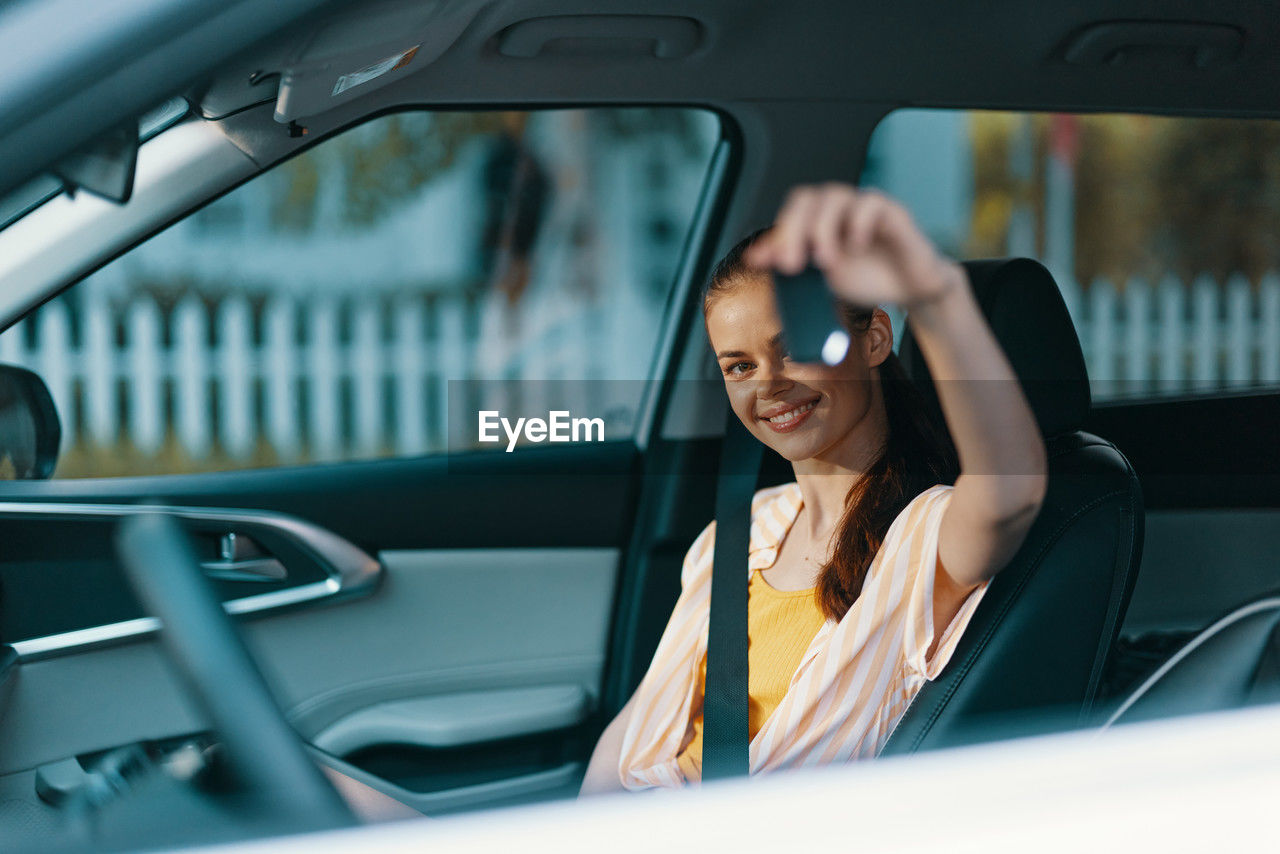 portrait of smiling young woman sitting in car