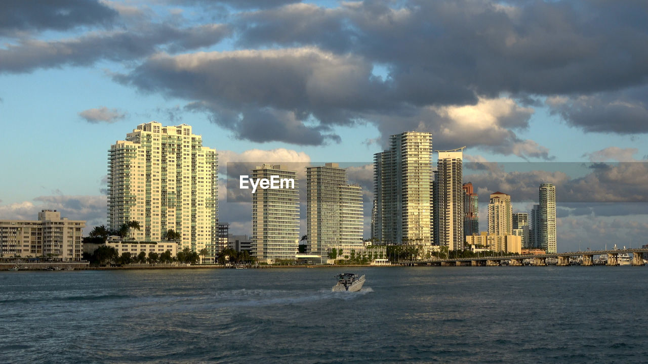 SEA BY CITY BUILDINGS AGAINST SKY