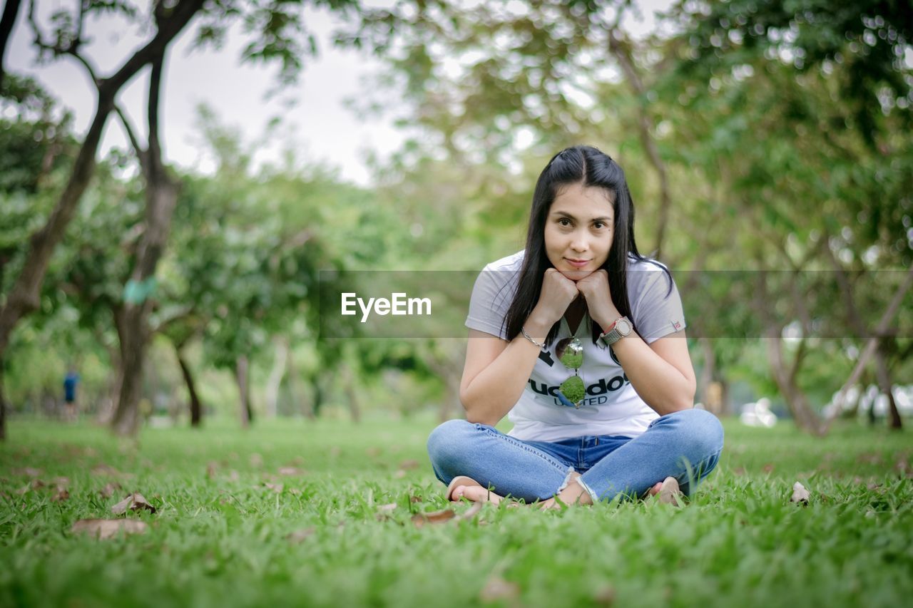 Portrait of young woman sitting on grass