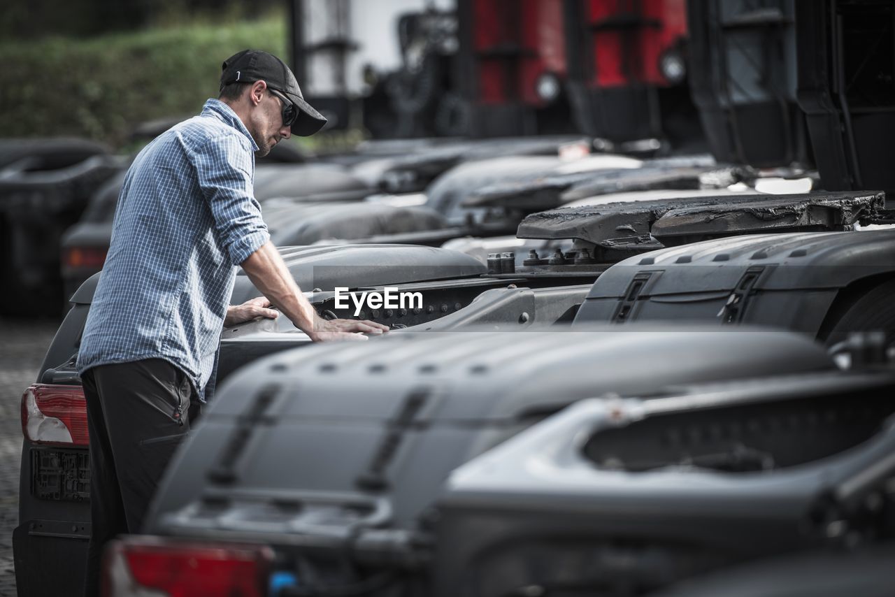 Man standing amidst cars