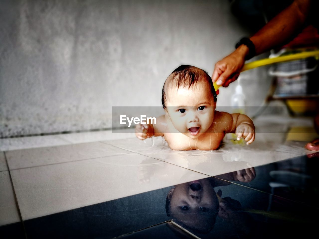 Portrait of cute baby boy having bath on floor