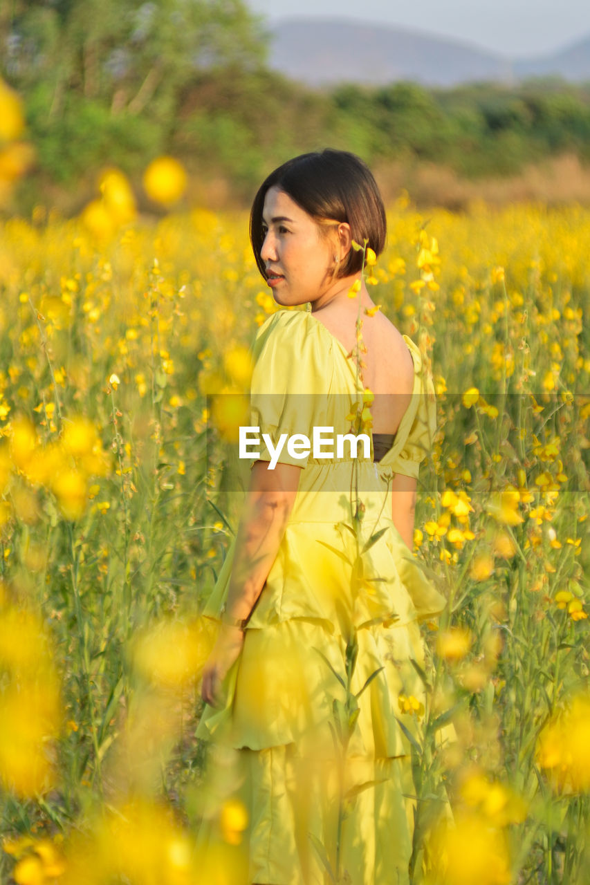 Girl standing on yellow flower field