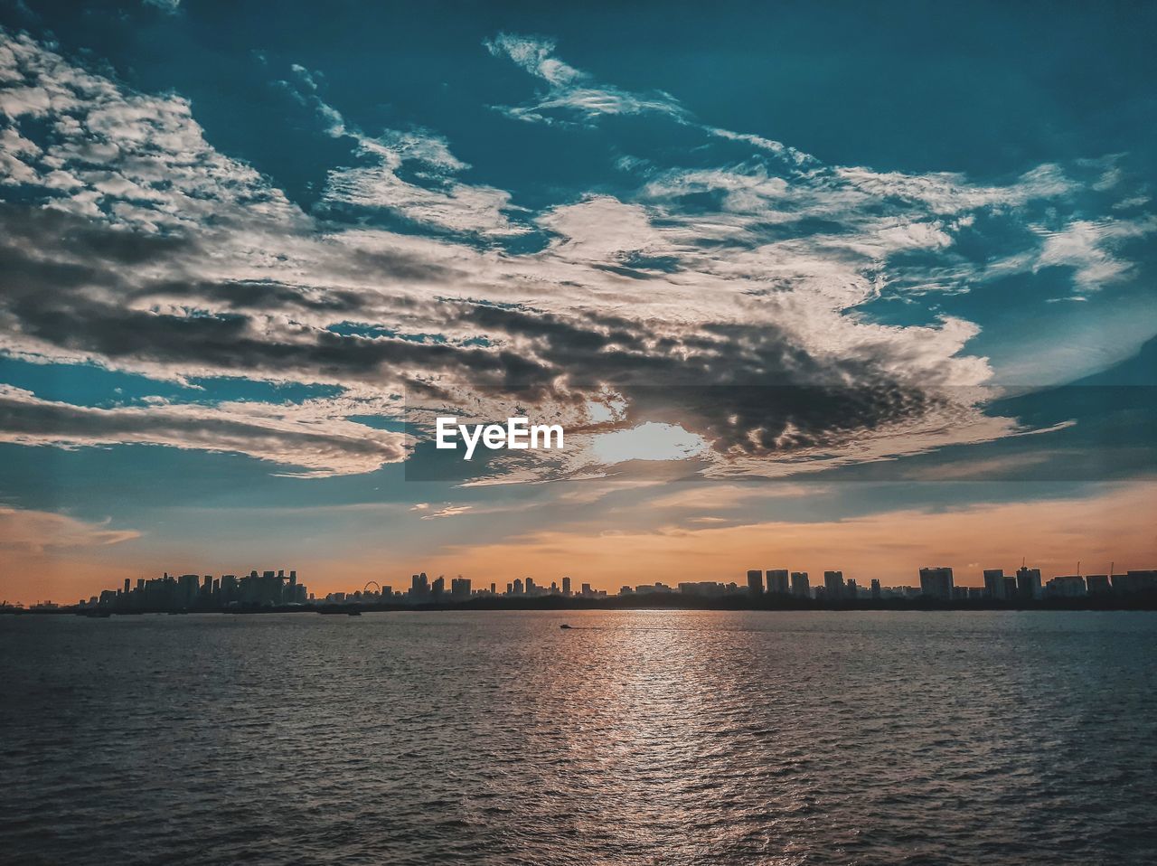 Scenic view of sea and buildings against sky during sunset