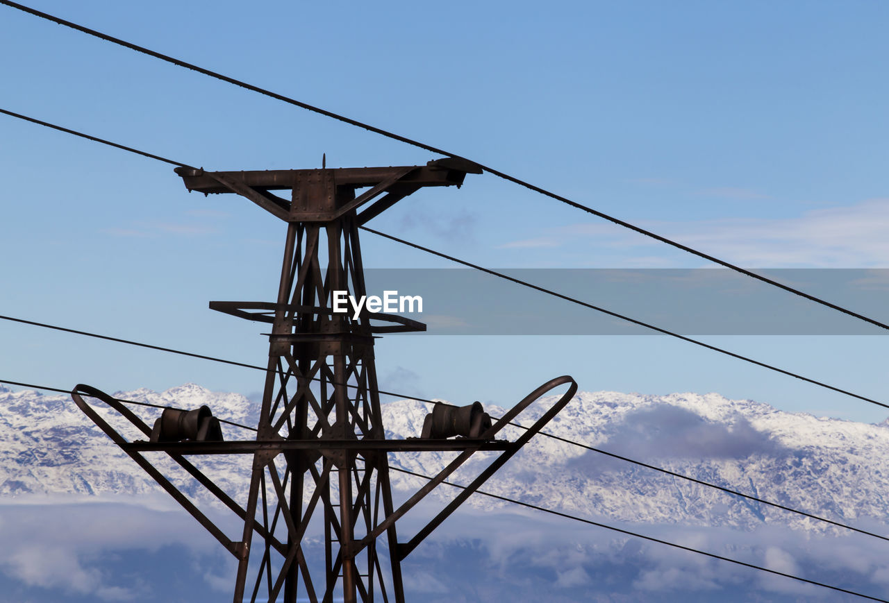 High section of electricity pylon against blue sky