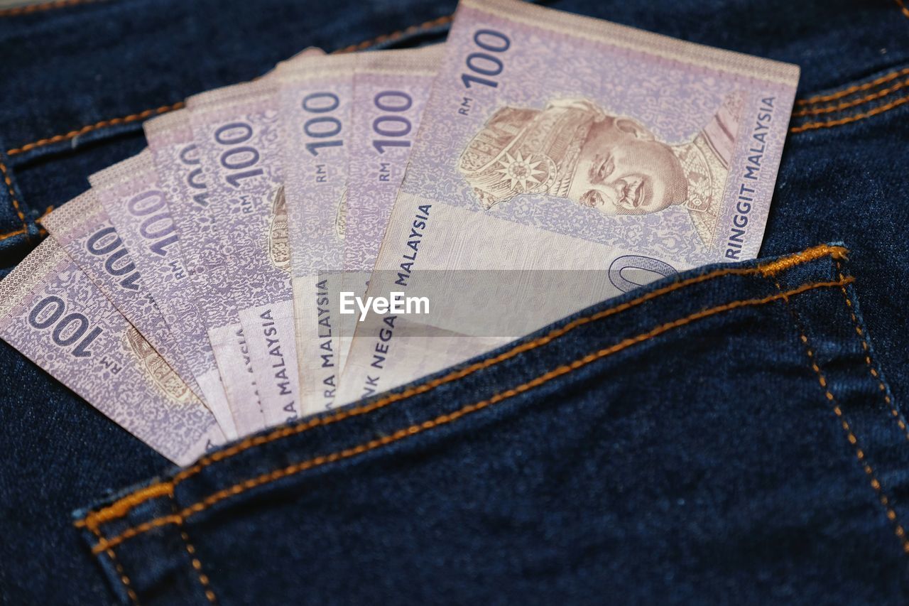Close-up of paper currencies in jeans pocket