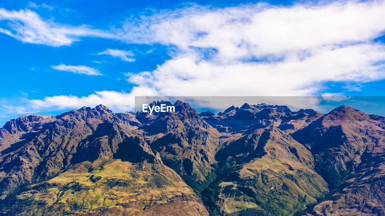 Scenic view of snowcapped mountains against blue sky