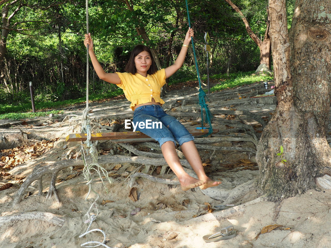 FULL LENGTH PORTRAIT OF SMILING YOUNG WOMAN ON LAND