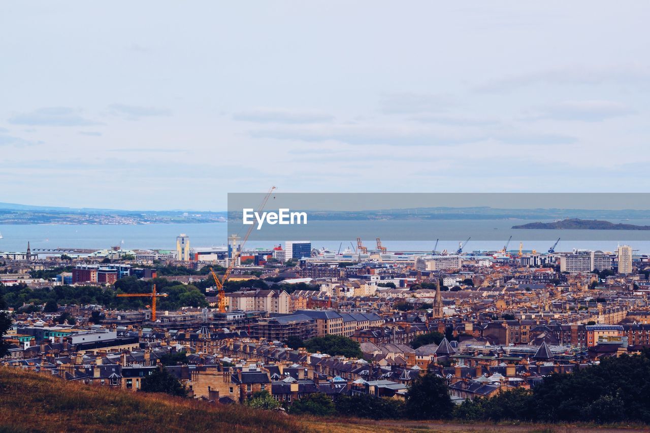 High angle view of townscape by sea against sky