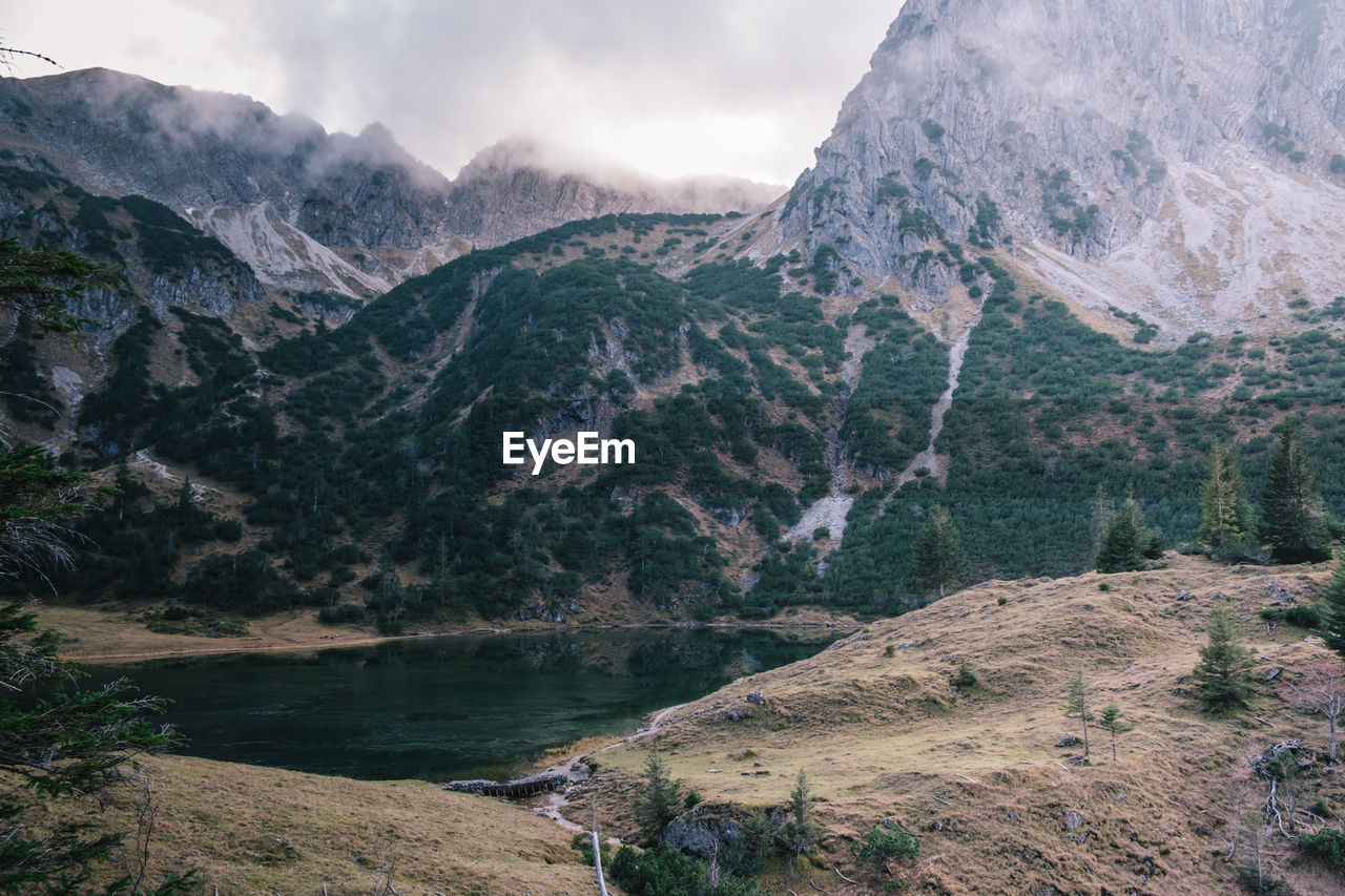 Scenic view of river amidst mountains against sky