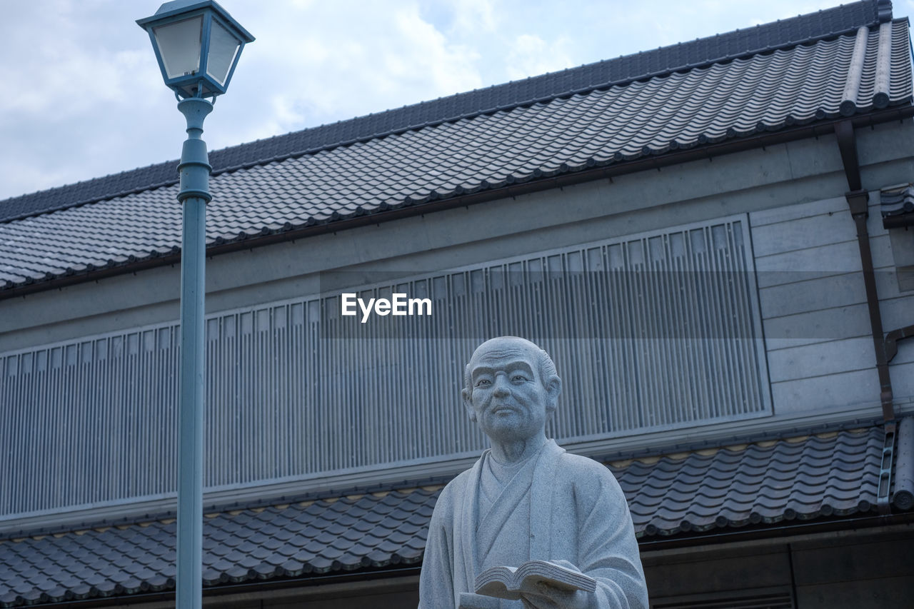 LOW ANGLE VIEW OF STATUE AGAINST BUILDING AND SKY