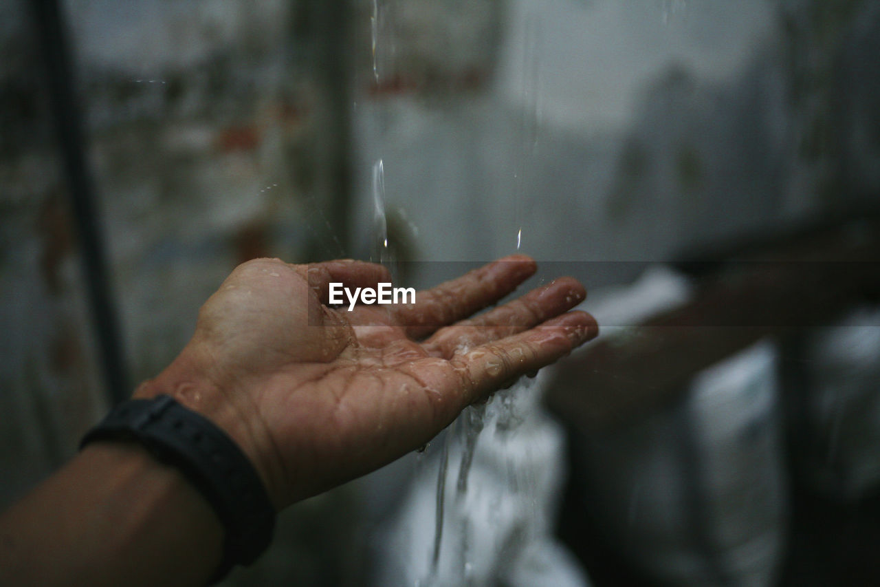 Close-up of wet hand in rainy season