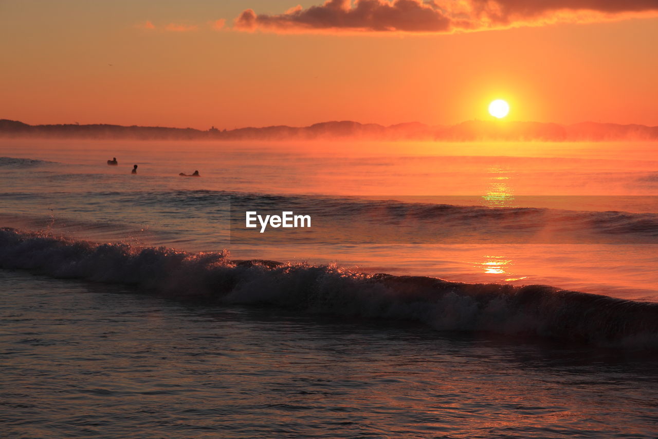 Scenic view of sea against orange sky