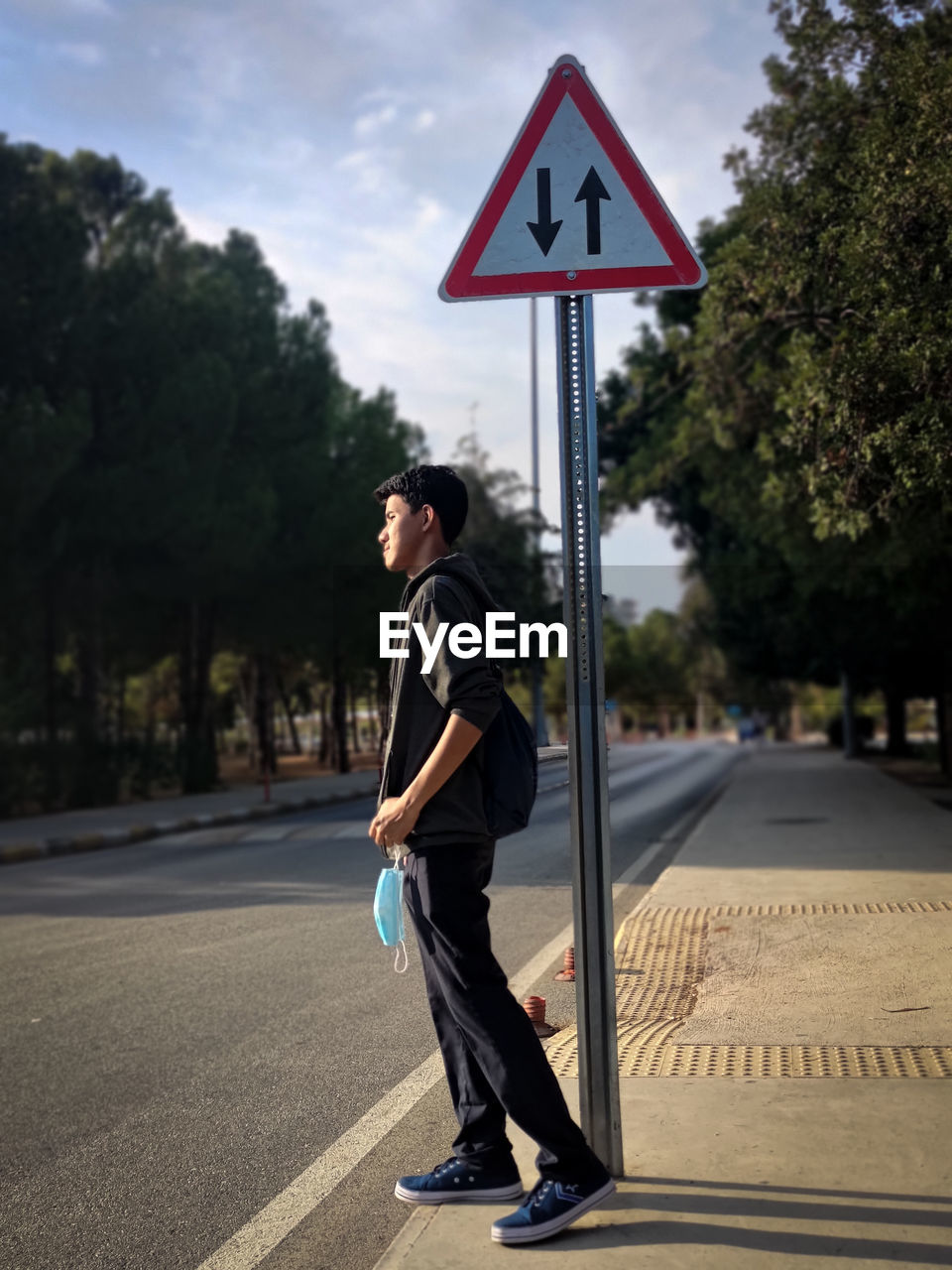 Side view of man standing on road