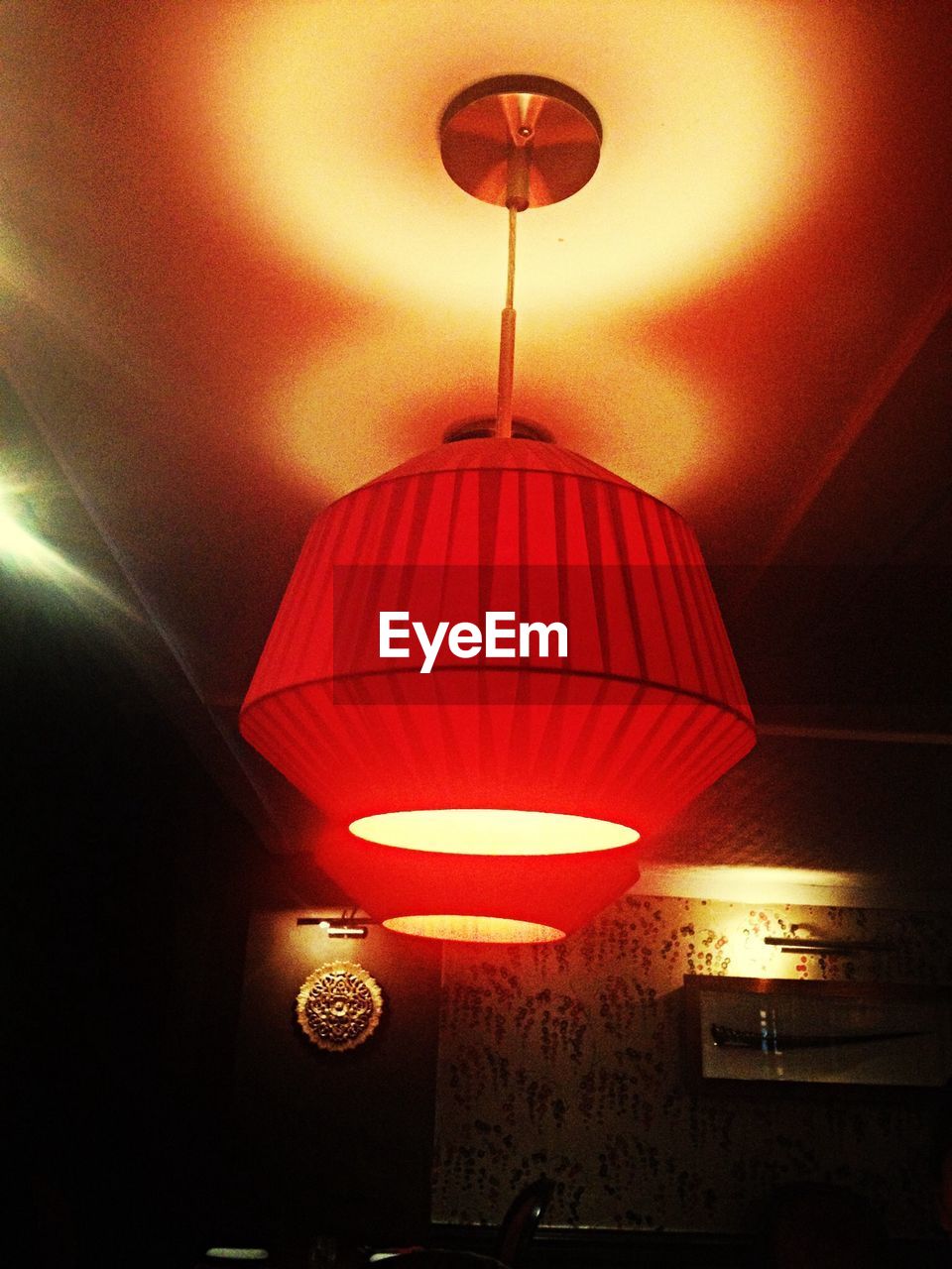 LOW ANGLE VIEW OF LIT LAMP HANGING ON CEILING