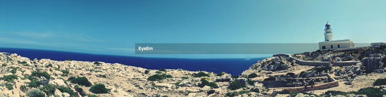 Panoramic shot of building by sea against blue sky