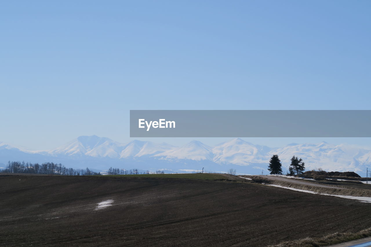 Scenic view of snowcapped mountains against clear blue sky