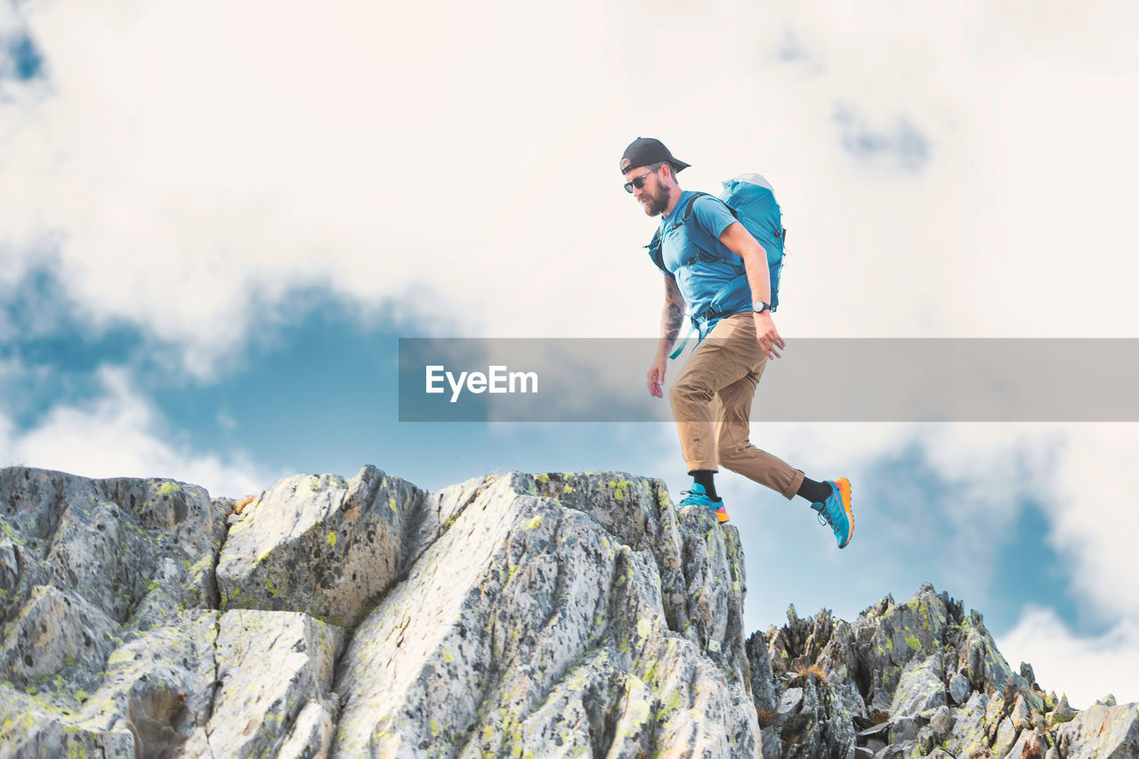 Man walks among boulders in the mountains in the italian alps