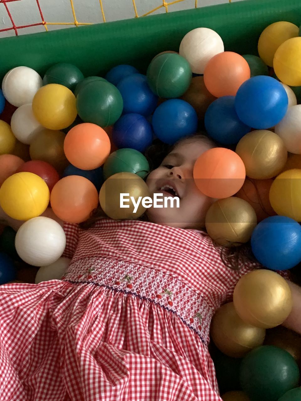 FULL LENGTH PORTRAIT OF BOY LYING IN MULTI COLORED CANDIES