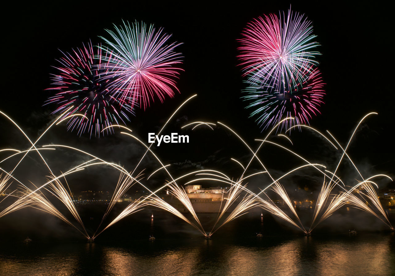 LOW ANGLE VIEW OF FIREWORKS DISPLAY AT NIGHT