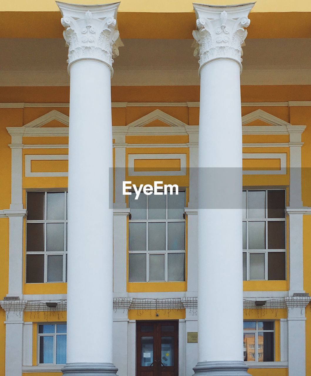 LOW ANGLE VIEW OF YELLOW BUILDING WITH WINDOWS