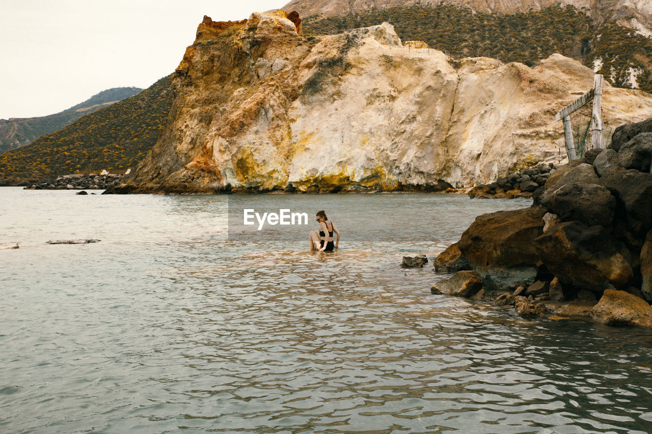 People on rock by sea