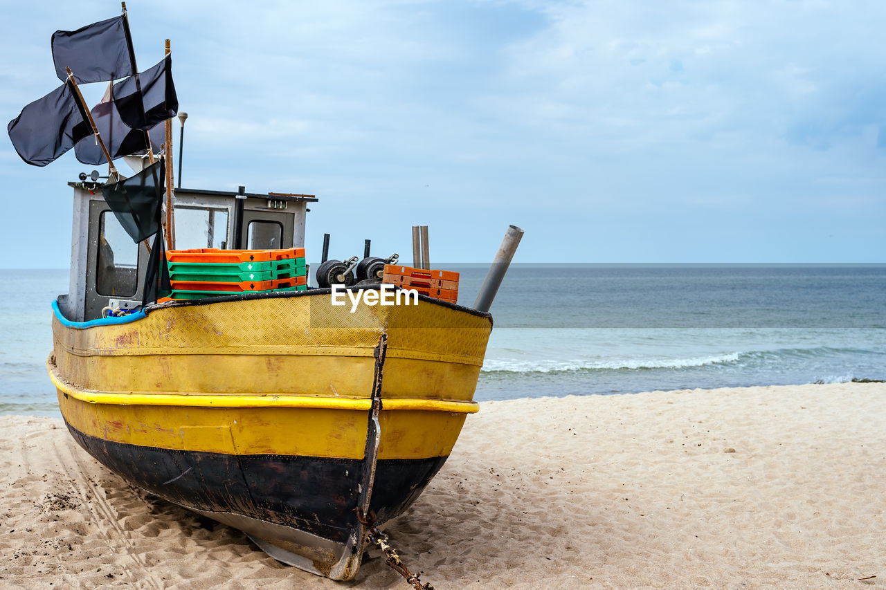 BOAT MOORED ON BEACH