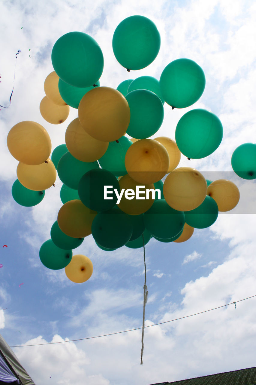 LOW ANGLE VIEW OF BALLOONS HANGING AGAINST SKY