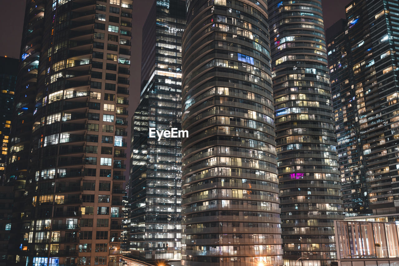 Low angle view of illuminated buildings in city at night