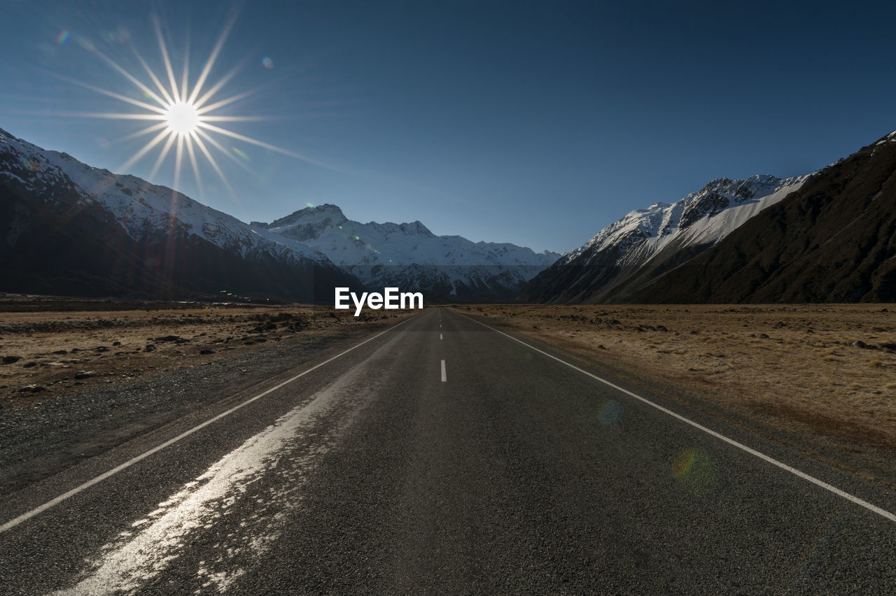 ROAD BY MOUNTAINS AGAINST SKY DURING SUNRISE