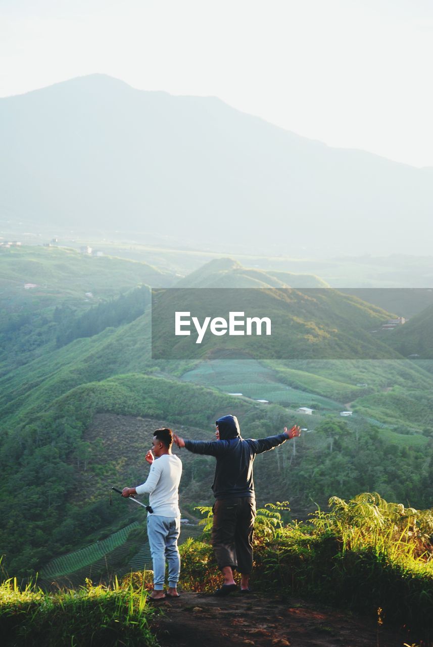 Rear view of friends standing on mountain