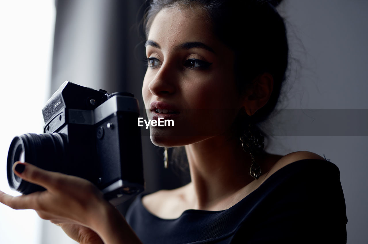 close-up of young woman looking through camera