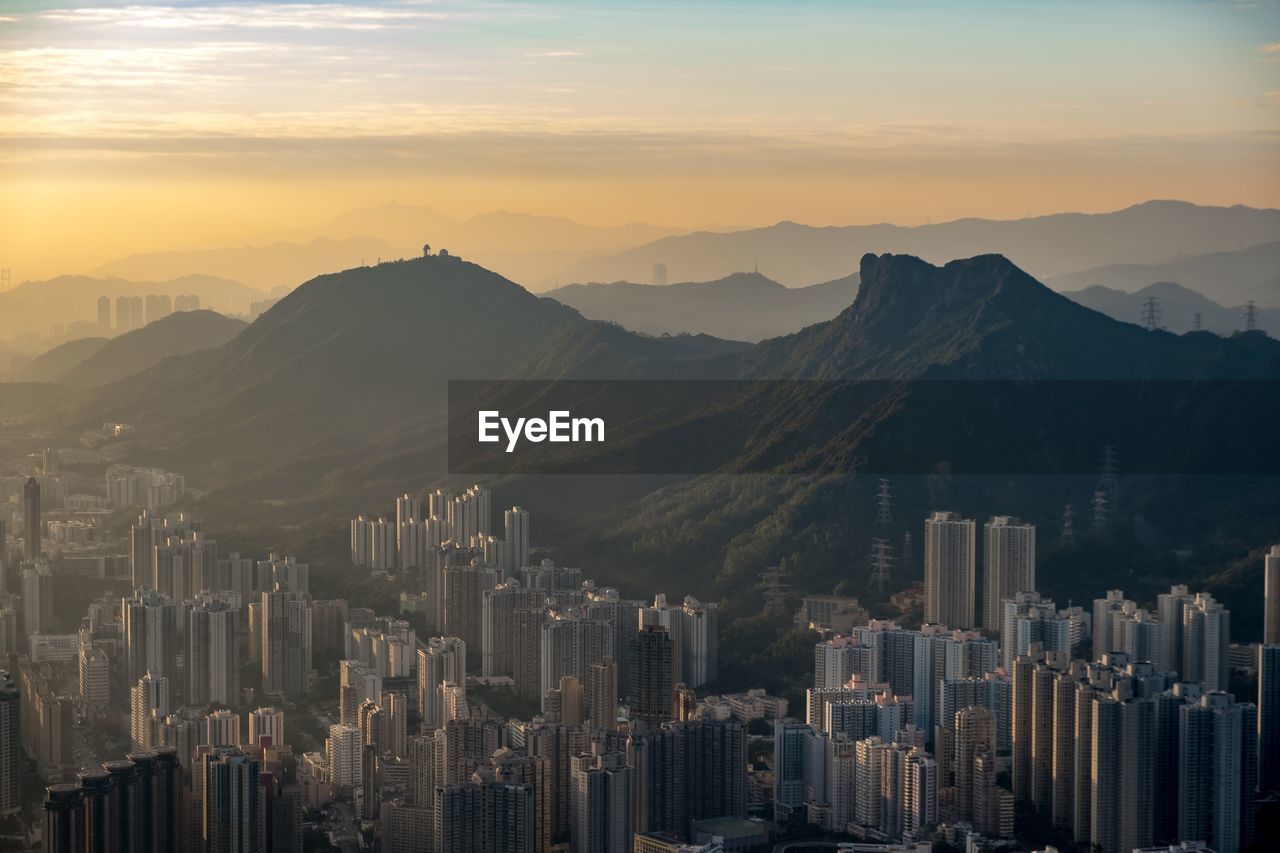 Aerial view of buildings in city at sunset