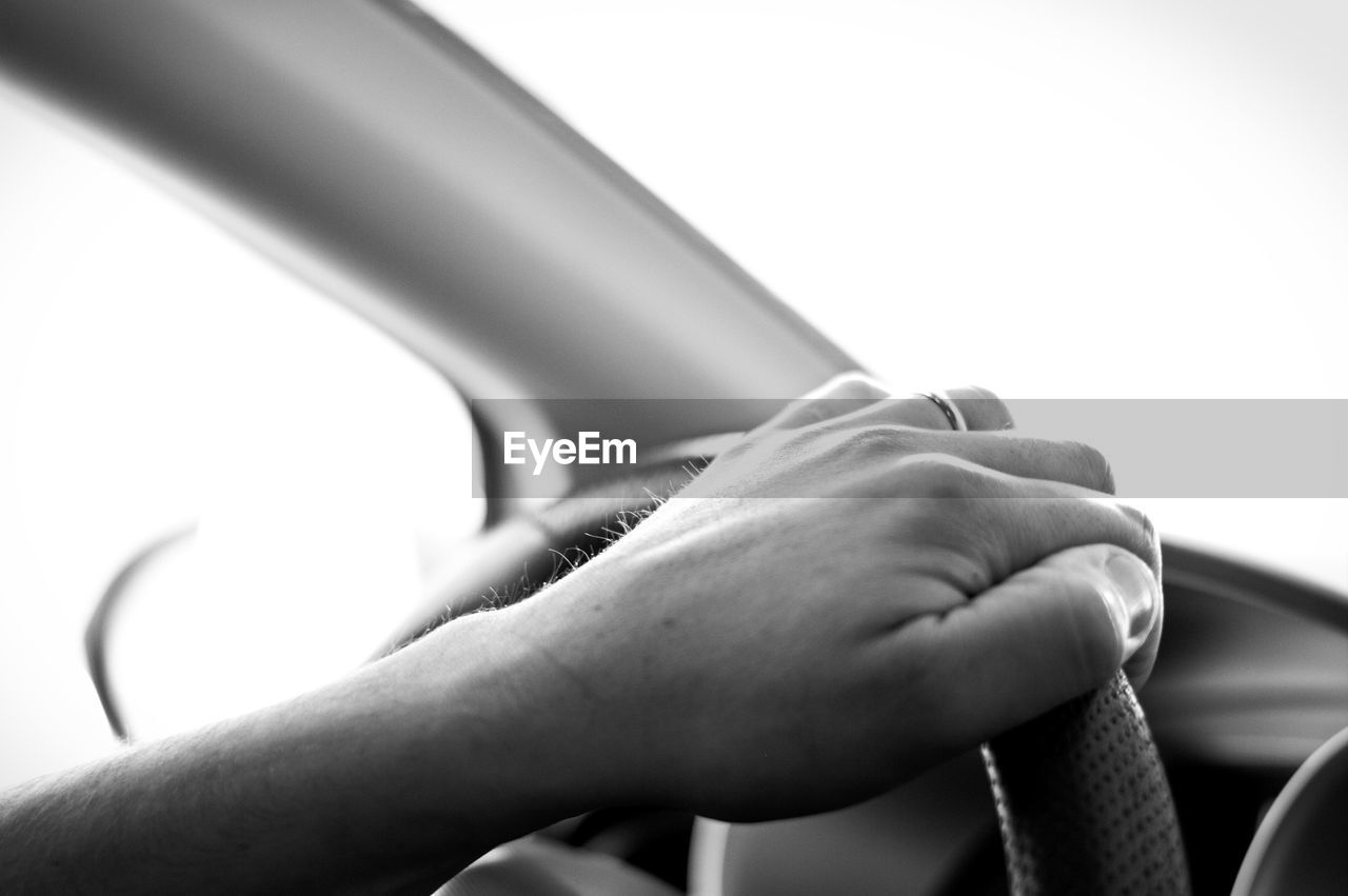 Cropped hand of woman on steering wheel