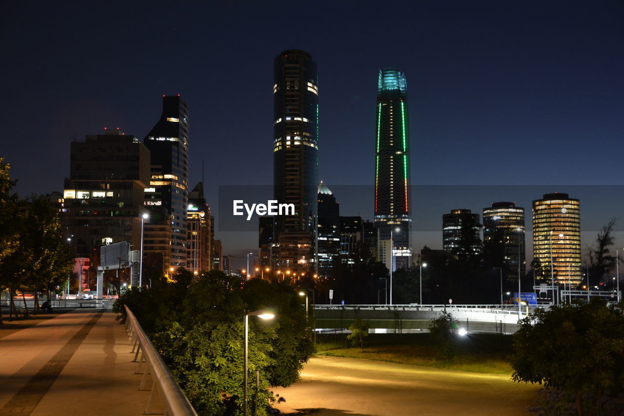 Illuminated city against clear sky at night