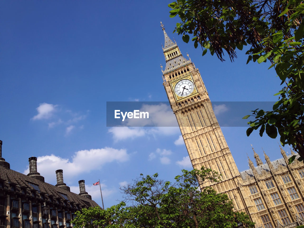 Low angle view of clock tower against blue sky