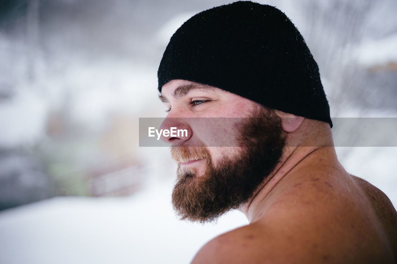 Close-up of bearded man on field during snowfall