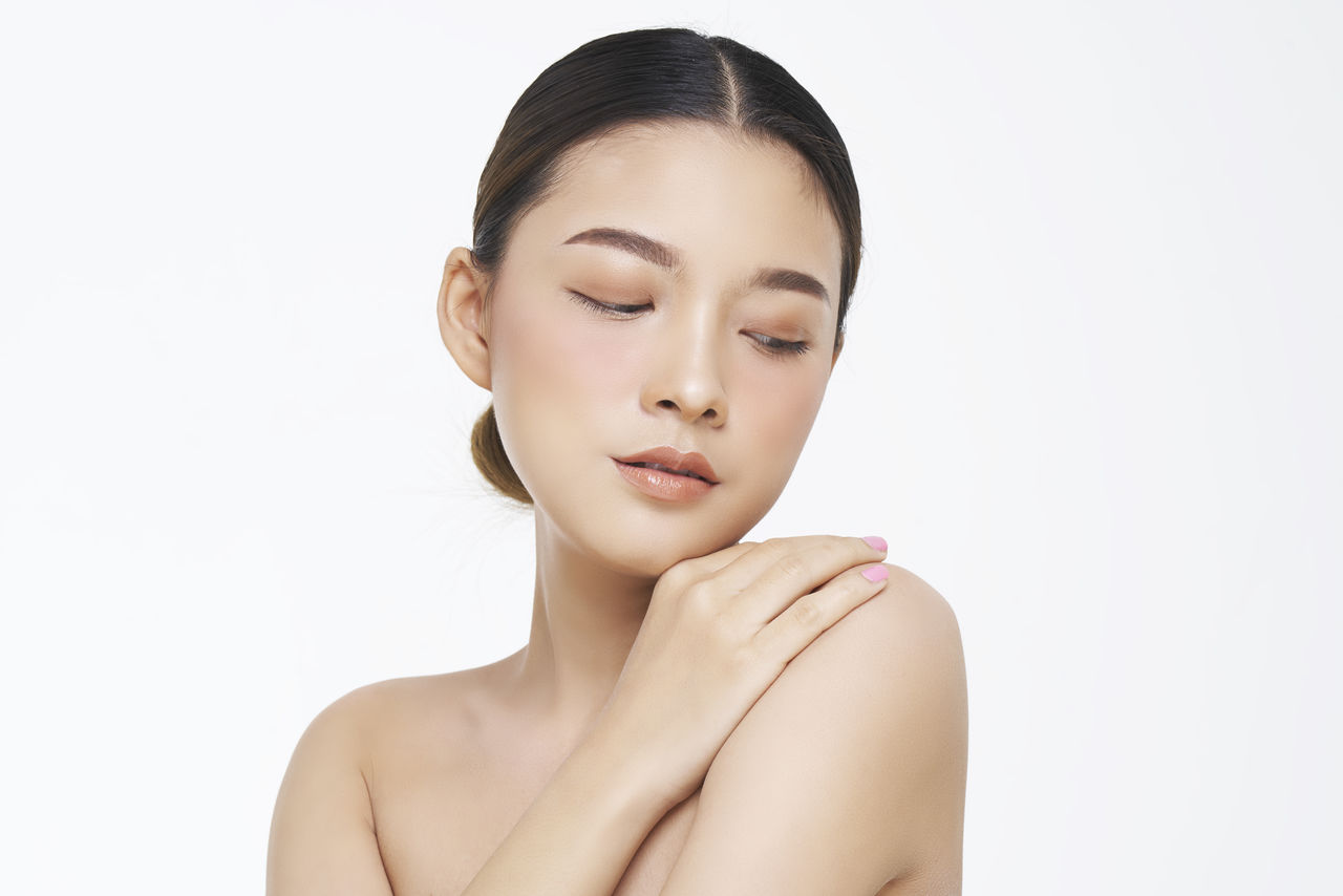 Close-up of thoughtful young woman over white background