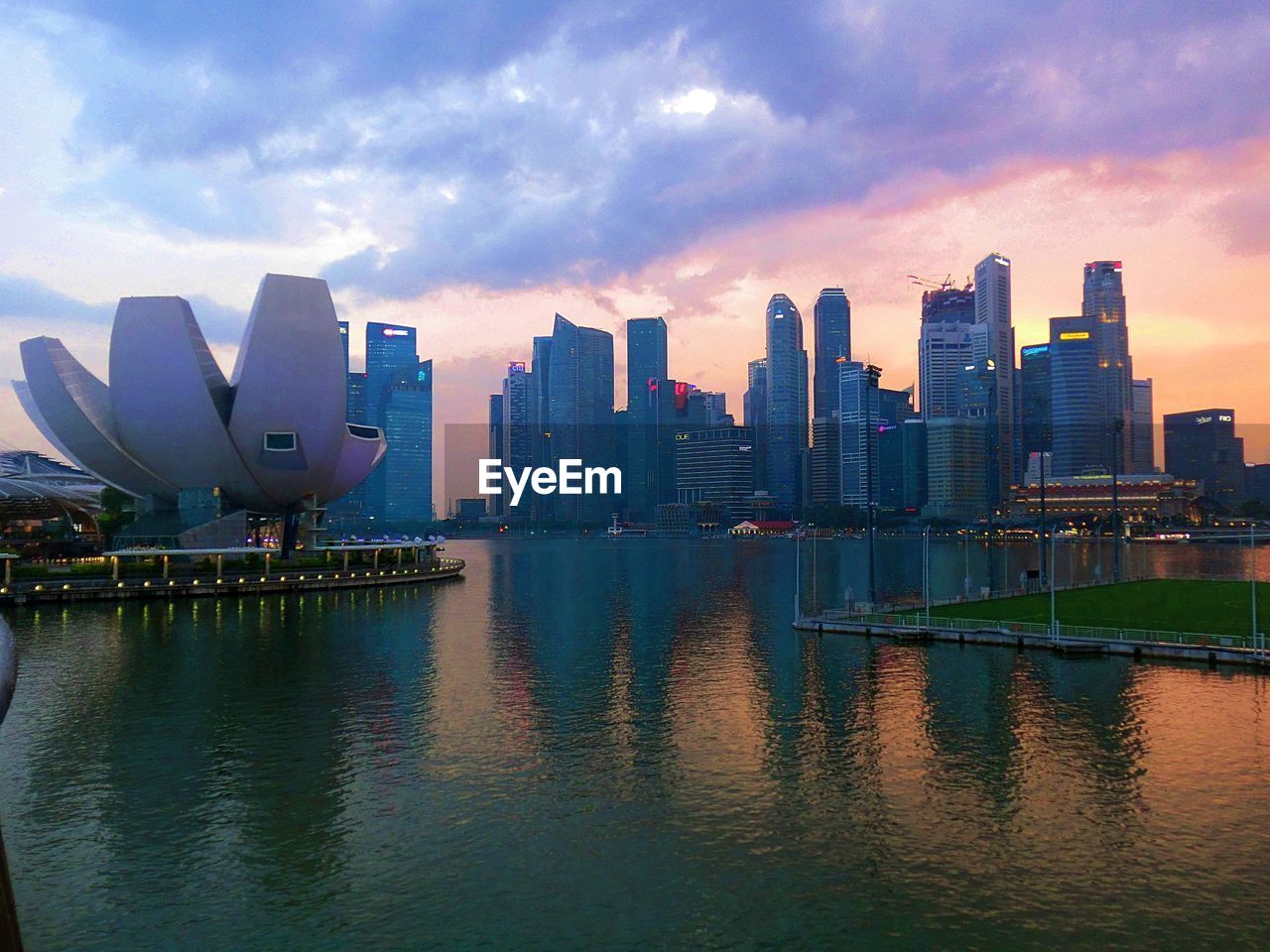 MODERN BUILDINGS BY RIVER AGAINST SKY