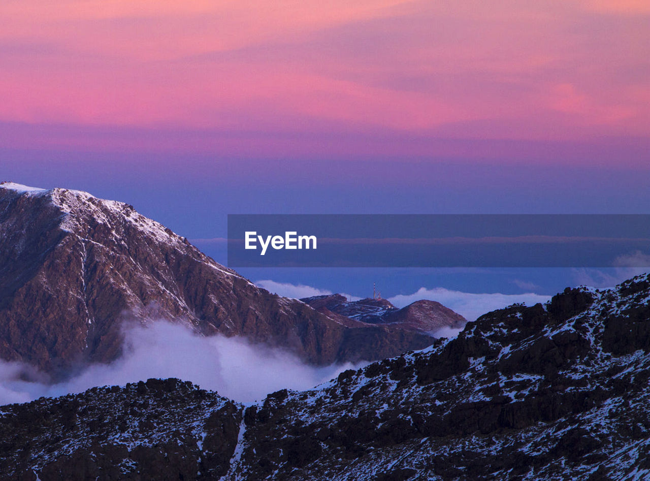 Scenic view of snowcapped mountains against sky during sunset