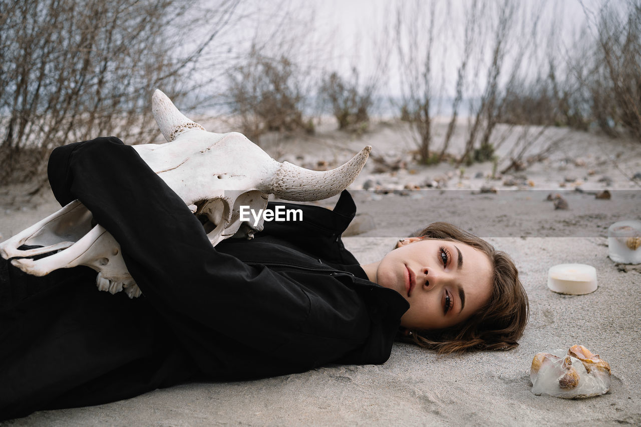 Portrait of young woman lying down on the beach