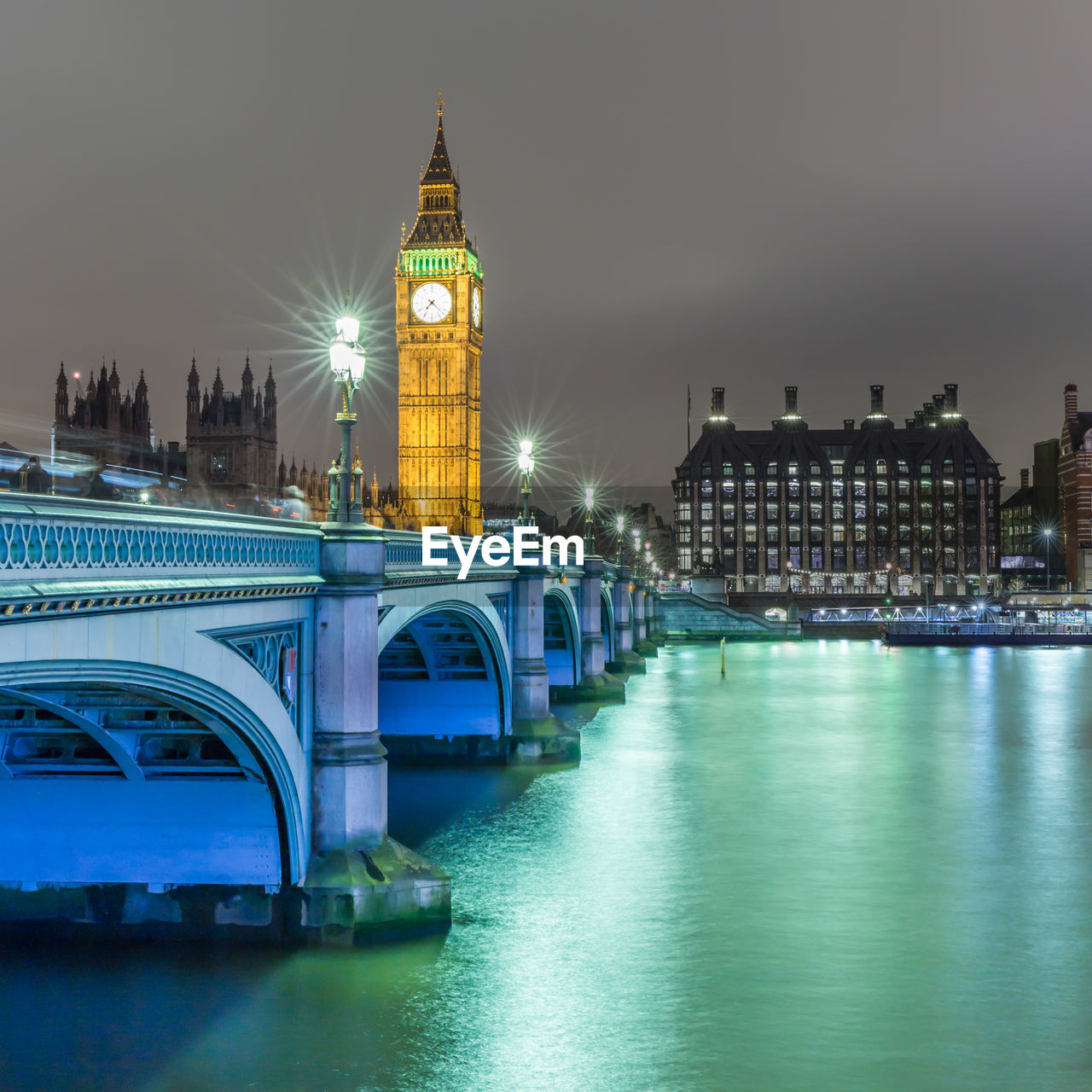 ILLUMINATED CLOCK TOWER BRIDGE AT NIGHT