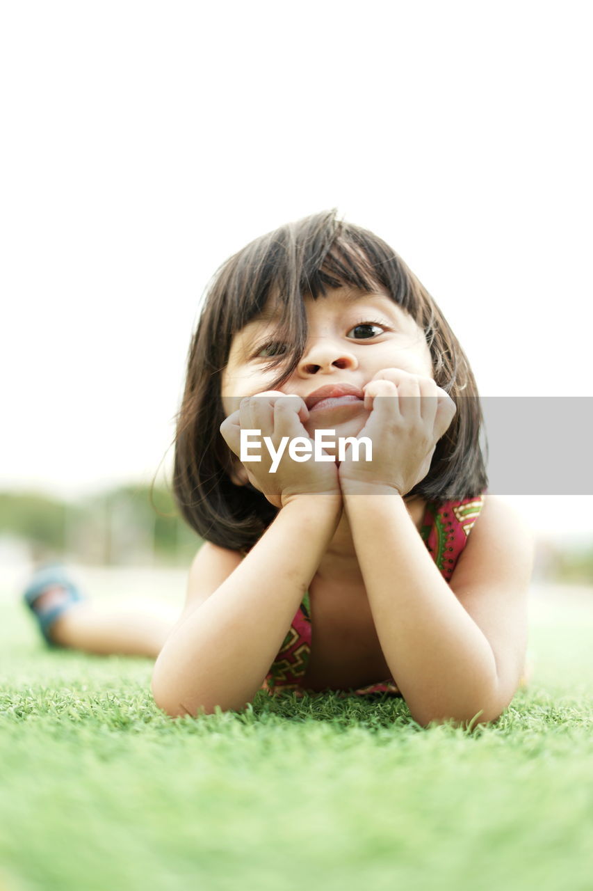 Portrait of girl lying on land at park